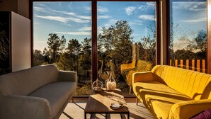 A modern living room with a large window, two sofas, a coffee table, and decorative items. - Nidos de Carnota (Carnota)