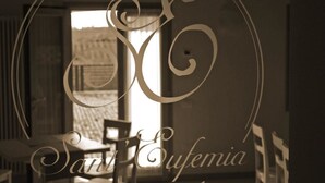 Ein Zimmer mit großem Fenster, einem Stuhl und einem Tisch.