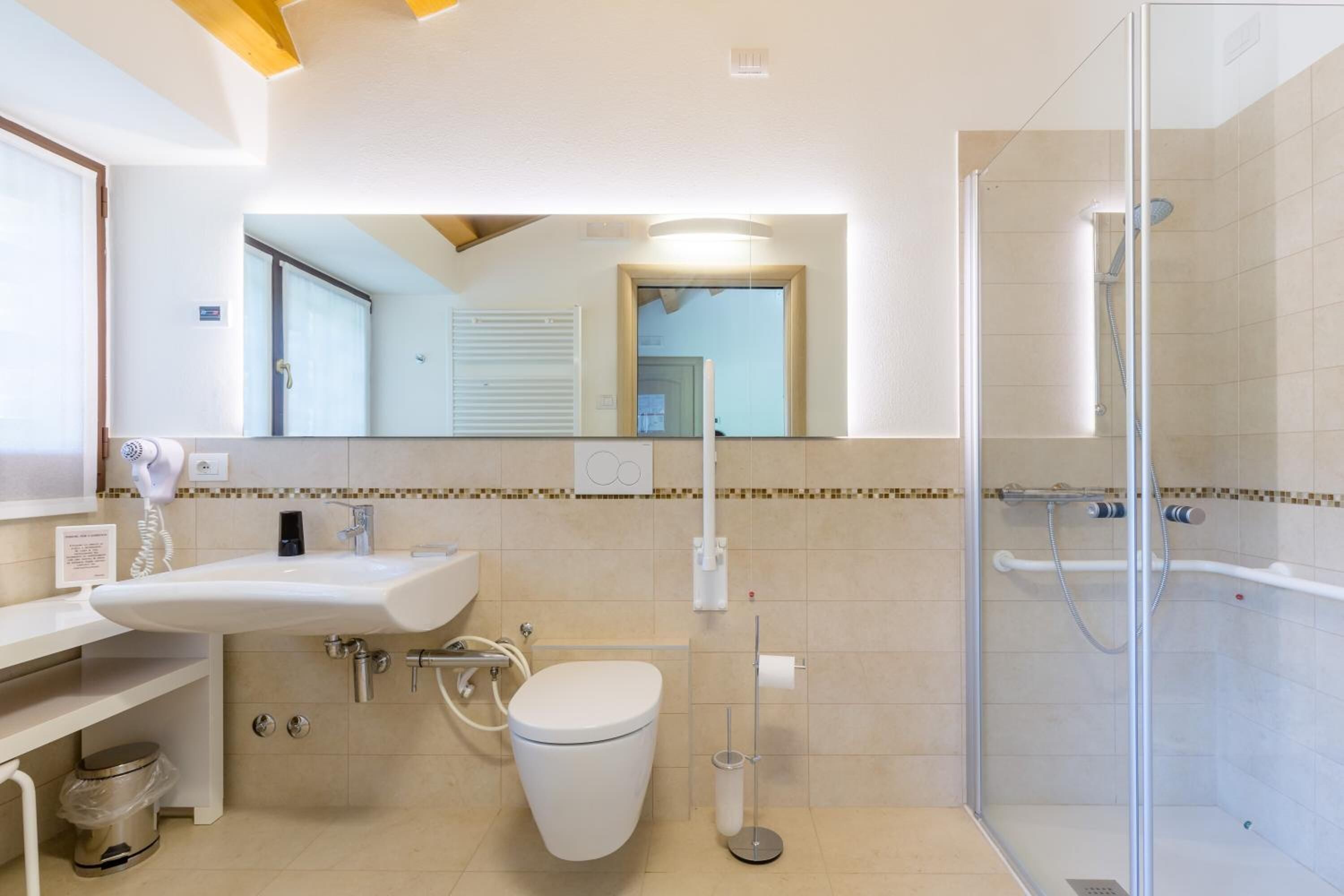 Une salle de bain moderne avec un lavabo blanc, des toilettes et une douche à parois de verre.