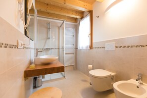 Habitación triple familiar, vista a la colina | Baño | Regadera, amenidades de baño gratuitas, secadora de cabello, bidet 