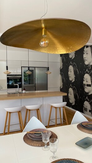 A modern kitchen with a central island, pendant lighting, and a wall mural. - Villa in the Biarritz Hills: Heated pool, garden, terrace, parking (Biarritz)