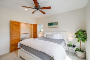 A bedroom with a bed, a ceiling fan, a window, a wall-mounted artwork, and a potted plant. - Buena Vista Home w/ Mtn Views, Walk to Main St (Buena Vista)