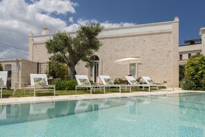 Een seizoensgebonden buitenzwembad en parasols bij het zwembad