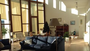 Un salón amplio con un sofá grande, una mesa de comedor y un árbol de Navidad.