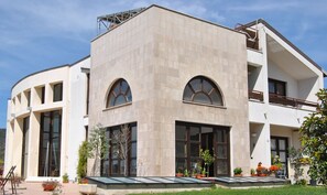 Un bâtiment moderne doté d’une façade incurvée, de grandes fenêtres en arc de cercle et d’un toit plat.
