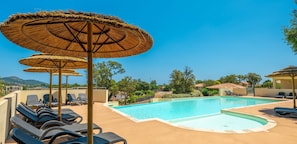 Piscine extérieure en saison, parasols, chaises longues
