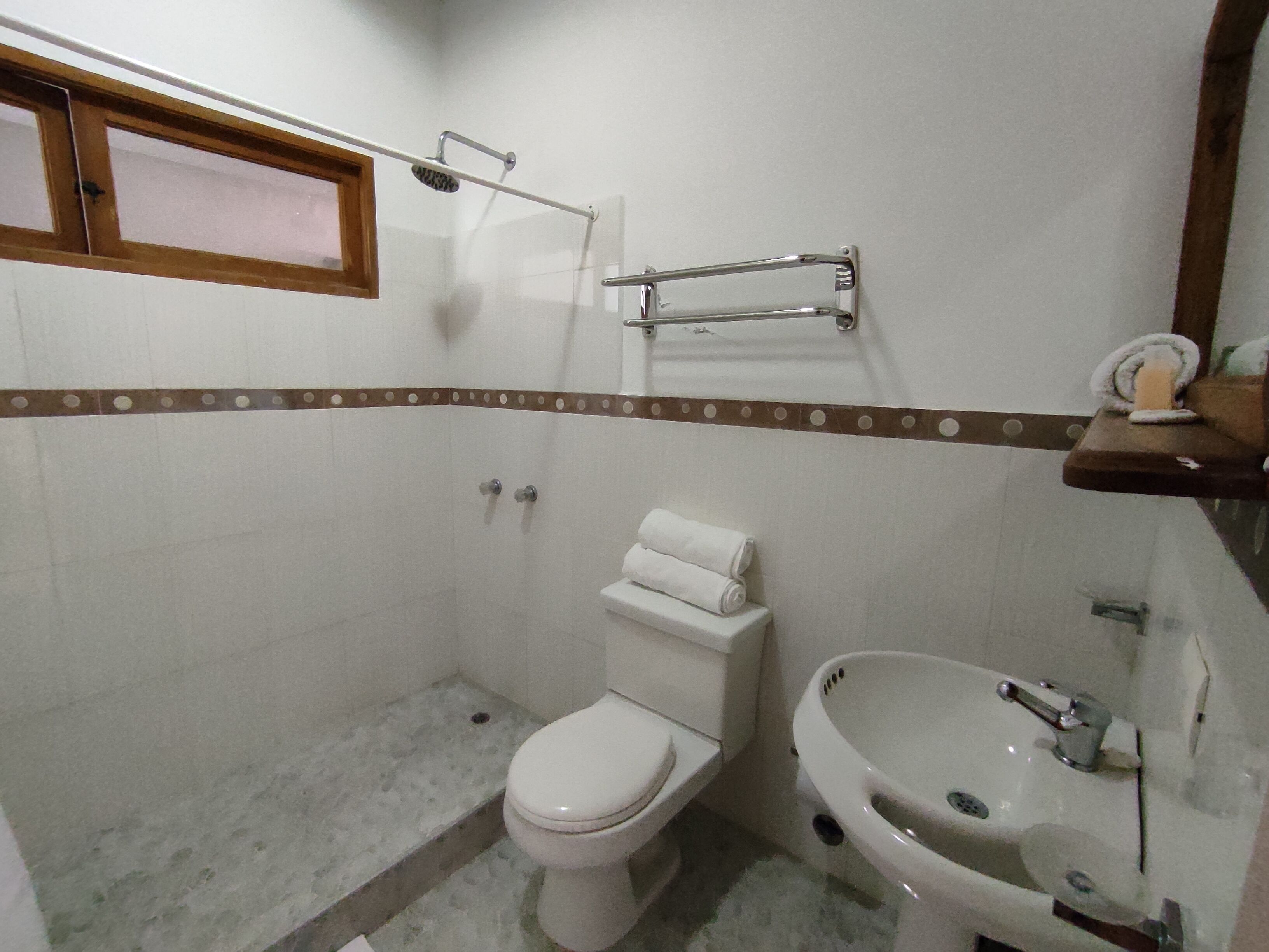 Un baño pequeño con inodoro, lavamanos y ducha.