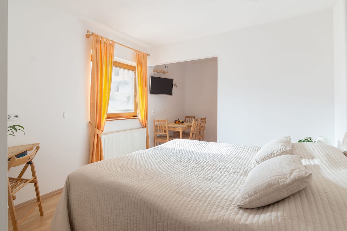 A bedroom with a bed, a desk, and a chair.