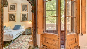A room with a bed, a wooden door, and a window. There are four framed pictures on the wall. - Factory Suites Barcelona (Barcelona)