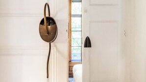 A white door with a brass doorbell and a black doorbell on the right. - Factory Suites Barcelona (Barcelona)