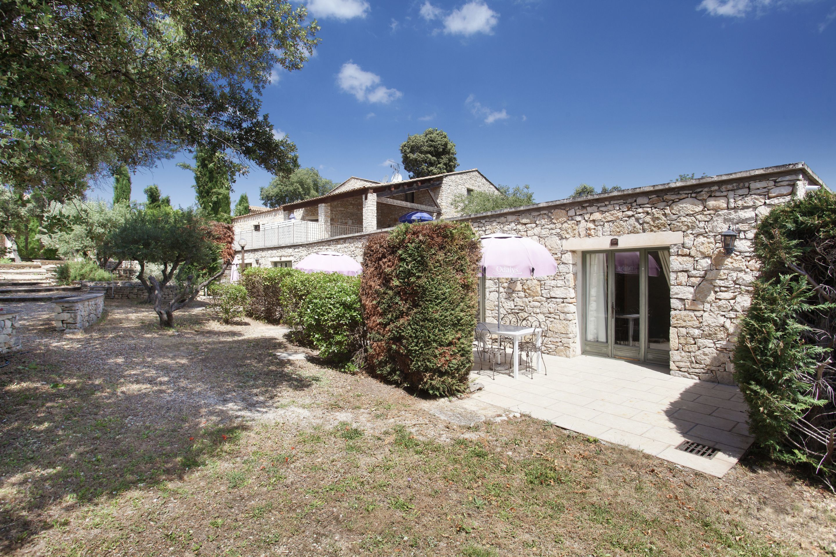 A stone building with a patio area, outdoor seating, and a covered entrance.