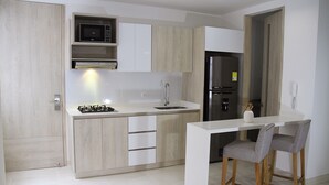 A modern kitchen with a white countertop, stainless steel appliances, and wooden cabinets. - Loft Mikonos - Adults Only (Pereira)