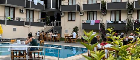 Un hôtel doté de nombreux balcons, d’une piscine et d’espaces de restauration en plein air.