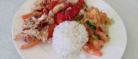 A plate with white rice, a salad, and a portion of grilled chicken.