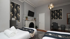 A hotel room with two beds, a television, a fireplace, and a desk. - Woodville Lodge Leeds Free Parking Direct Bus to City Centre (Leeds)