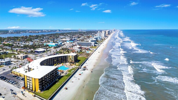 A coastal cityscape with a prominent curved hotel, a beach, and a clear view of the ocean. - First Floor Private Paradise Ocean Front Studio SPRING SALE! POOL OPEN!! (Daytona Beach)