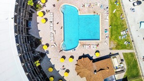 A rooftop pool with sun loungers and umbrellas, surrounded by a high-rise building. - First Floor Private Paradise Ocean Front Studio SPRING SALE! POOL OPEN!! (Daytona Beach)