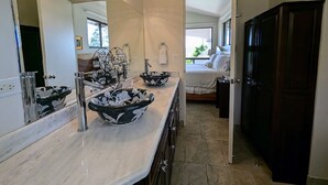 A bathroom with a large mirror, two black and white patterned bowls, and a dark wooden door. - Stunning views of Lake Arenal & Volcano in Secure Safe Gated Vacation Community (Tronadora)