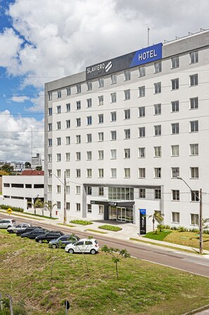 A modern hotel building with multiple floors and a prominent 'HOTEL' sign. - SLAVIERO Curitiba Aeroporto (Sao Jose dos Pinhais)