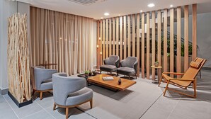 A modern lounge area with a sofa set, a coffee table, and a lounge chair. - SLAVIERO Curitiba Aeroporto (Sao Jose dos Pinhais)