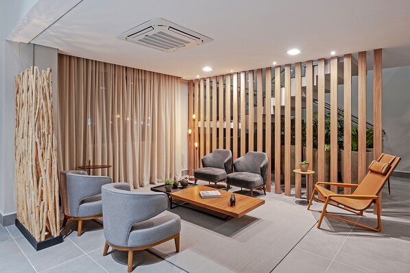 A modern lounge area with a sofa set, a coffee table, and a lounge chair. - SLAVIERO Curitiba Aeroporto (Sao Jose dos Pinhais)