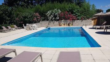 Relax by the pool surrounded by comfortable seating and lush greenery.
