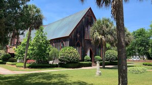 A large, rustic building with a steeply pitched roof and wooden exterior, surrounded by well-maintained gardens and trees. - Luxury Home in Old Town Bluffton + FREE Golf Cart. Sleeps 8 - Downtown location (Bluffton)