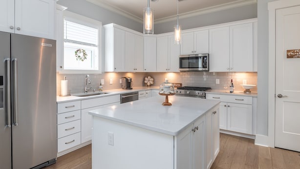 A modern kitchen with white cabinetry, stainless steel appliances, and pendant lighting. - Luxury Home in Old Town Bluffton + FREE Golf Cart. Sleeps 8 - Downtown location (Bluffton)