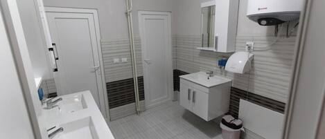 Un baño moderno con dos lavamanos, un espejo y un inodoro.