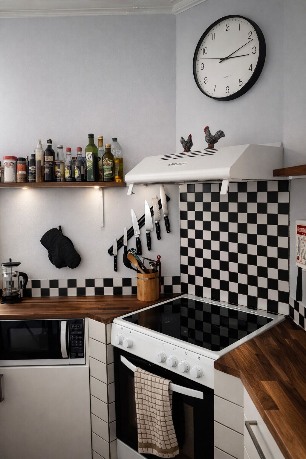 Refrigerador em uma área comum, micro-ondas, fogão, cooktop