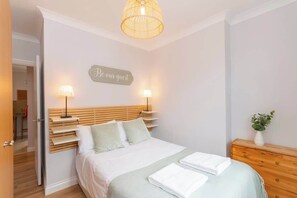 2 habitaciones, escritorio y tabla de planchar con plancha