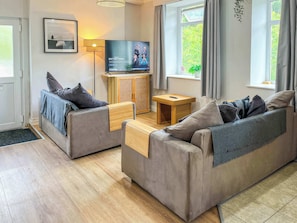 A modern living room with two sofas, a television, a small table, and a cabinet. - The Nook at Afan Forest Park by STAE-Homes (Duffryn Rhondda)