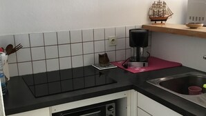 A kitchen with a black countertop, a coffee maker, a toaster oven, and a clock on the wall. - PLEASANT STUDIO CABIN PARKING SEA AT 80M (Canet-en-Roussillon)