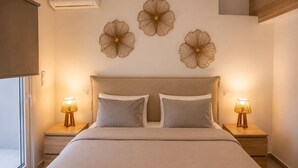 Een slaapkamer met een bed, twee bedlampen en drie decoratieve items aan de muur.