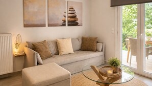 Een woonkamer met een bank, een glazen salontafel en uitzicht door een schuifdeur.