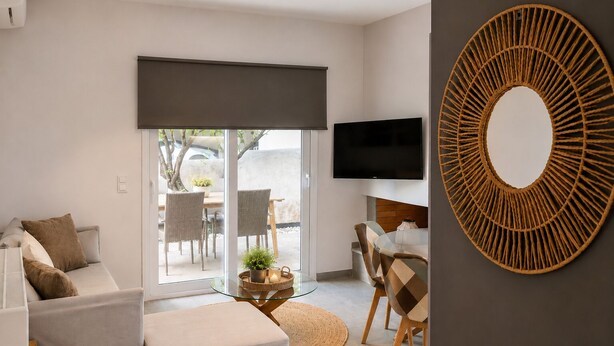 Een moderne woonkamer met een bank, een salontafel en een aan de muur bevestigde televisie.