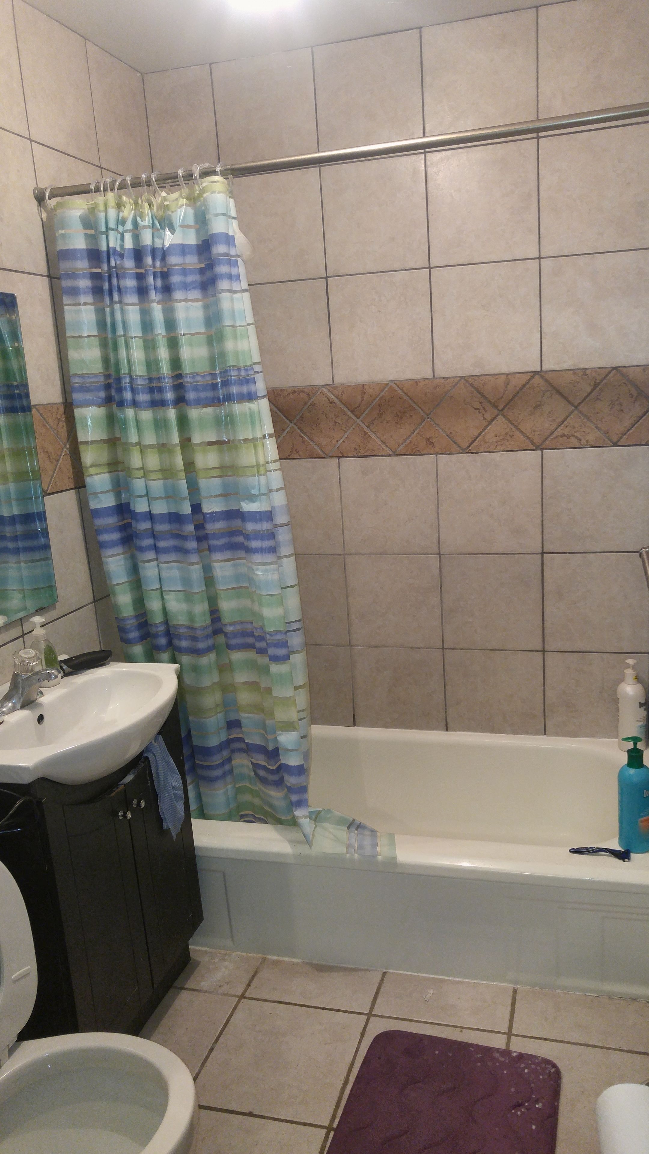 Ein Badezimmer mit Badewanne, Waschbecken, Toilette und Duschvorhang.