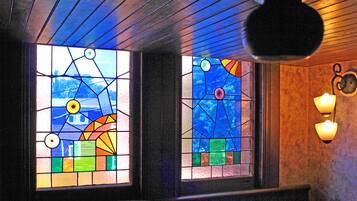 Dos vidrieras con diseños geométricos y un aplique de pared.