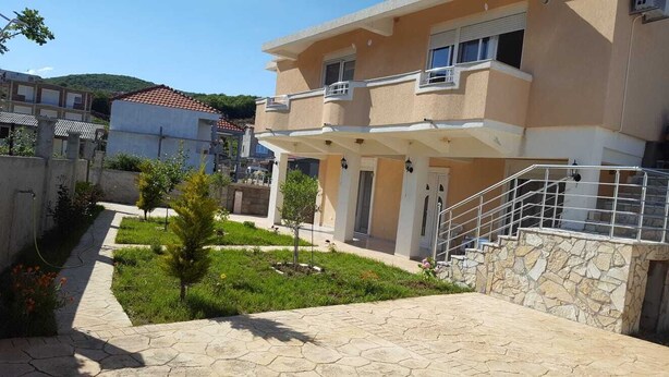 Ein zweistöckiges Gebäude mit einer Steintreppe, die zu einem Balkon führt.