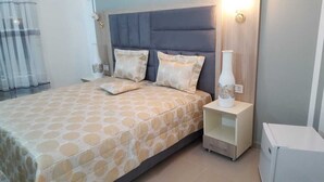 Ein Schlafzimmer mit einem Bett, zwei Kissen, einem Nachttisch und einem Beistelltisch.