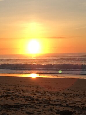 Un atardecer sobre una playa con olas.