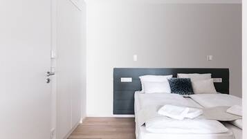 Un dormitorio moderno con cama, armario y puerta.