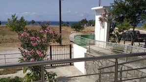 Zona residencial com vista para o mar, área externa coberta e escadaria que leva a uma varanda.