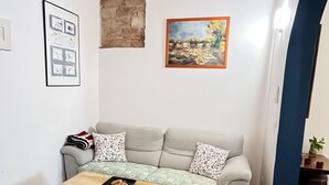 Una sala de estar con un sofá, una mesa de centro y un cuadro en la pared.