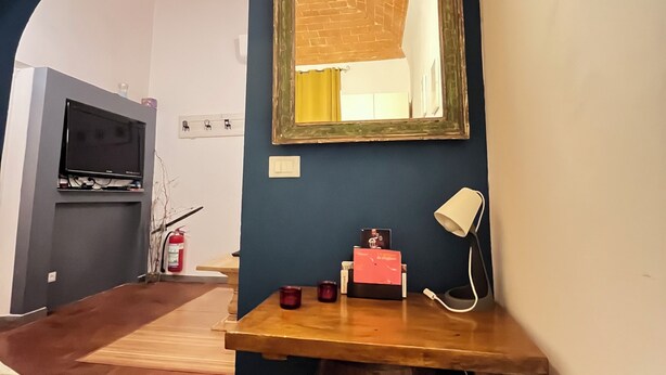Una habitación con una mesa de madera, un espejo, una lámpara y un extintor.