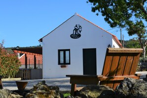A small building with a black logo, a window, and a door. - Quinta do Tio Viagem (Palmela)