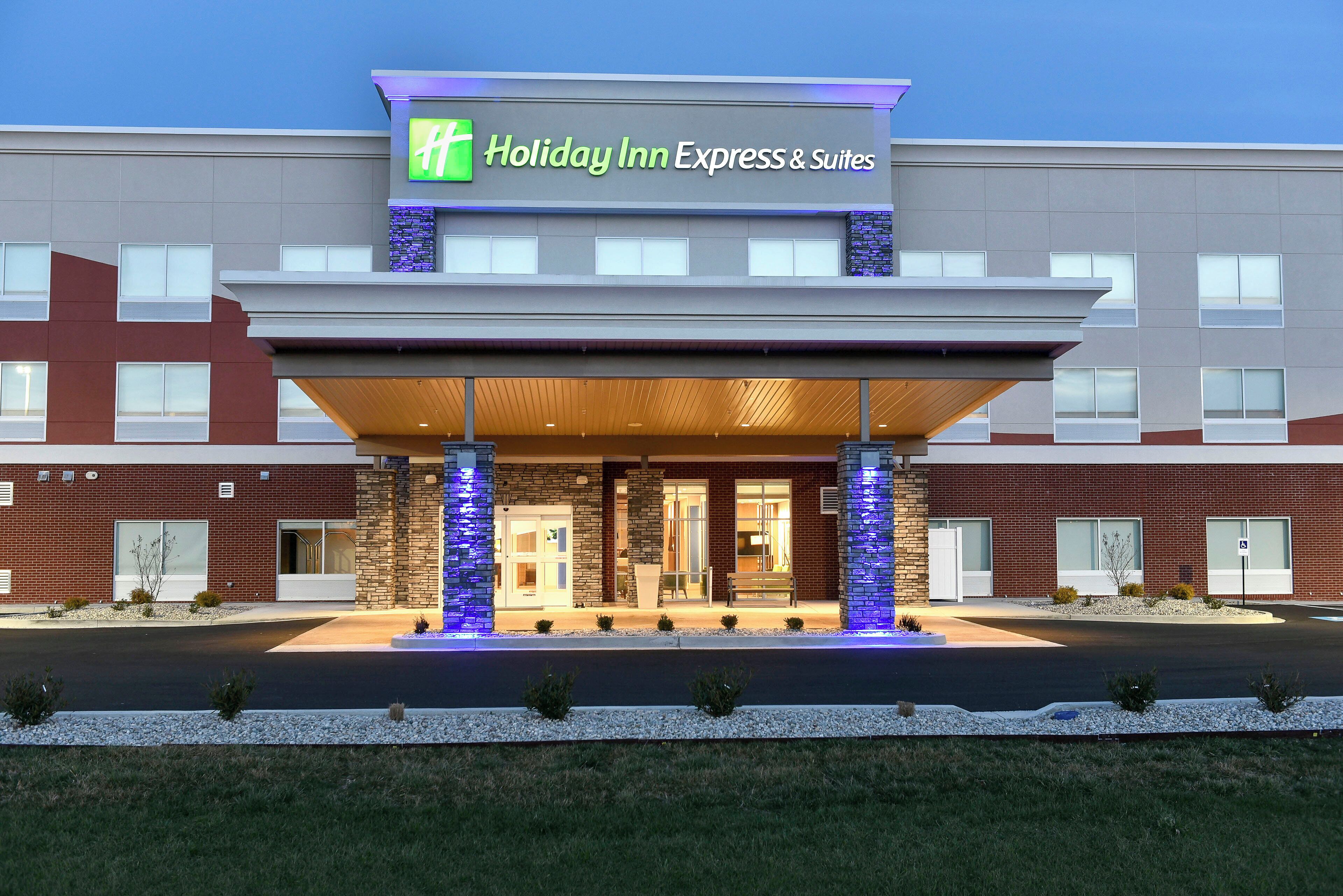 Edificio de Holiday Inn Express & Suites con entrada cubierta, múltiples ventanas y un letrero sobre la entrada.
