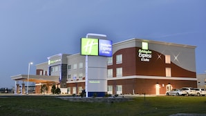 A Holiday Inn Express & Suites building with a prominent sign, a covered parking area, and a brick facade. - Holiday Inn Express & Suites Madisonville by IHG (Madisonville)