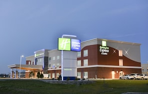 A Holiday Inn Express & Suites building with a prominent sign, a covered parking area, and a brick facade. - Holiday Inn Express & Suites Madisonville by IHG (Madisonville)