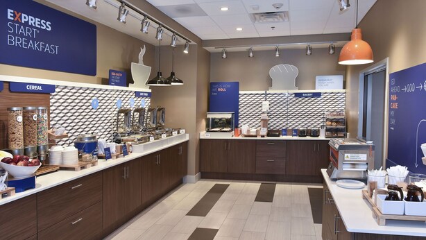 A breakfast area with a cereal station, a bakery section, and a coffee machine. - Holiday Inn Express & Suites Madisonville by IHG (Madisonville)